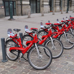 Das Bild zeigt aufgereihte Leihräder in rot an einer Leihstation. 
