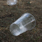Aufnahme eines Plastikbechers auf vertrocknetem Rasen.