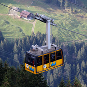 Die Seilbahnen befördern Menschen schnell zu den Berggipfeln. Eine gelbe Seilbahn in den Alpen