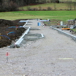 Eine Straße wird auf einer grünen Wiese gebaut.