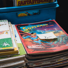 Für manche ist der Gebrauchtkauf eine preiswerte Alternative, für viele Menschen gehört er außerdem zum nachhaltigen Lebensstil. Nahaufnahme eines Comic-Stapels.