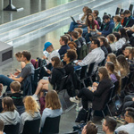 Stühle mit Menschen, die an einer Diskussion teilnehmen.