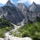 Hohes, kantiges Gebirge im Hintergrund und weiche grüne Büsche im Vordergrund