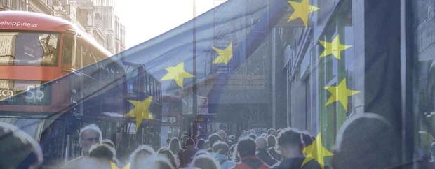EU-Flagge, im Hintergrund laufende Menschen
