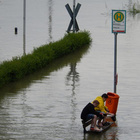 Durch den Klimawandel steigt die Häufigkeit von Extremwetterereignissen wie Stürmen oder Starkregen. Diese können Hochwasser oder Erdrutsche auslösen und bedeuten somit eine unmittelbare Gefahr für Leib und Leben. Zwei Jungs, die auf einer Bank sitzen. Um sie herum hat sich ein See gebildet.