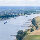 Luftbild: Blick auf den Rhein. Links im Bild der Fluss, rechts Wiesen und Felder in Ufernähe und ein Deich
