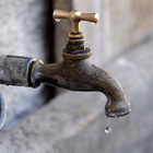 Wasserhahn mit Wassertropfen.