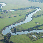 Ein Fluss schlängelt sich durch eine grüne Landschaft.