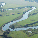 Ein Fluss schlängelt sich durch eine grüne Landschaft.