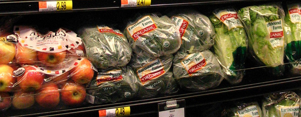 In Plastikfolie verpacktes Obst und Gemüse im Kühlregal eines Supermarktes