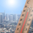 Ein Thermometer bei 40 Grad Celcius, im Hintergrund eine Großstadt bei Sonnenschein