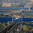 Die Oberrheinlandschaft hat sich durch die Rheinbegradigung im 19. Jahrhundert stark verändert. Das Bild zeigt den Grenzübergang zwischen Deutschland (Bildvordergrund) und Frankreich (Bildhintergrund) bei Breisach am Rhein. Im Vordergrund der begradigte Oberrhein mit einer Schleusenanlage. Der Rheinseitenkanal im Hintergrund wurde für die Schifffahrt angelegt.