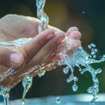 Hände unter einem Wasserhahn