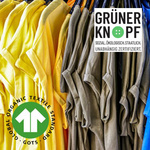 Farbige T-Shirts an Kleiderbügeln mit GOTS und Grüner Knopf Siegeln