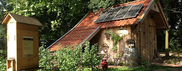 Scheune mit Solaranlage im Vordergrund ein Bienenschaukasten