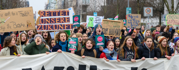 Jugendliche protestieren mit großem weißen Banner und Plakaten.