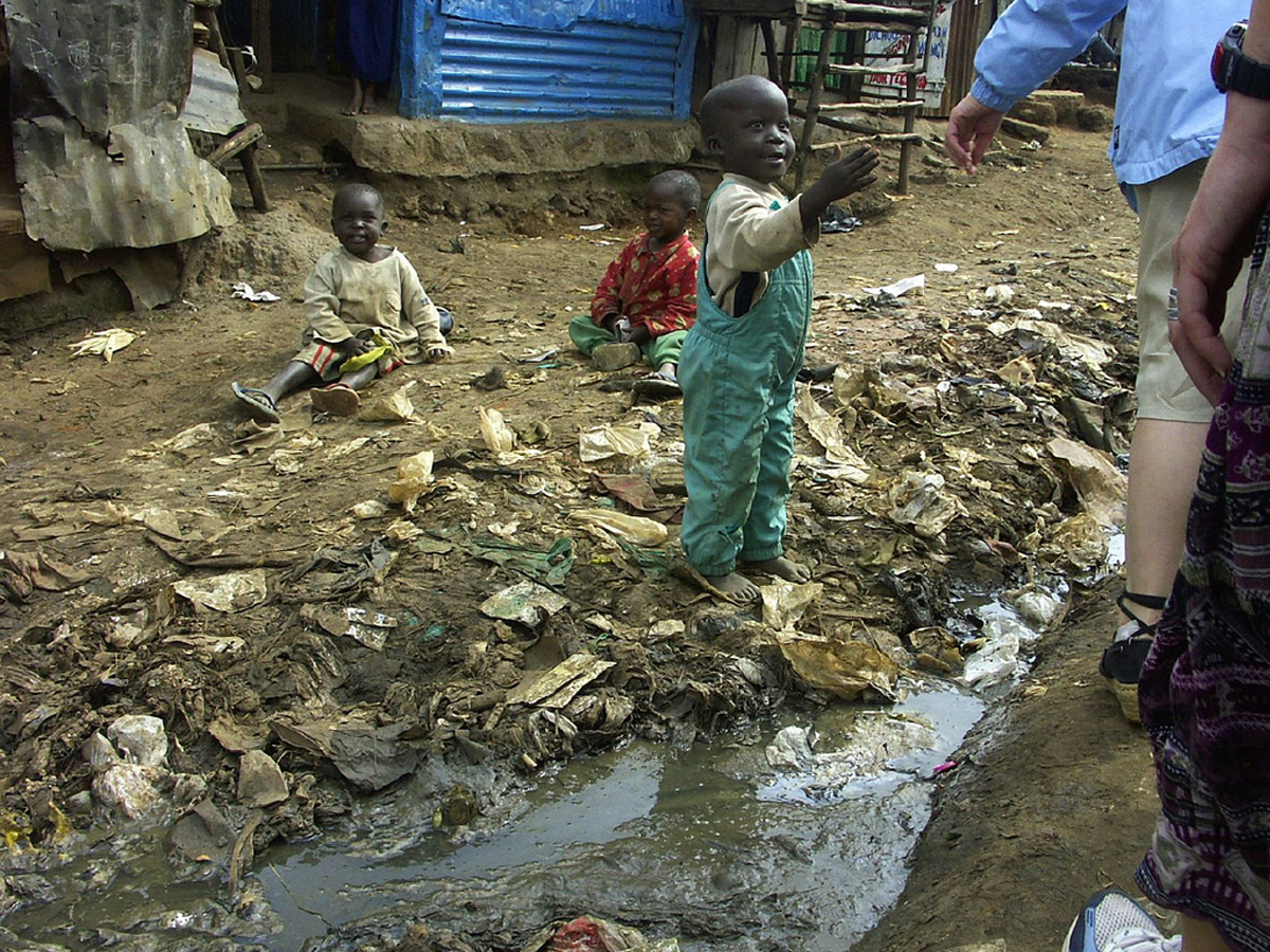 Kinder an einem schmutzigen Gewässer in Afrika