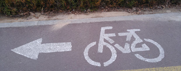 Fahrradweg mit aufgedrucktem Fahrrad und Pfeil