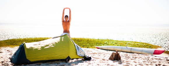 Person vor Zelt am Strand