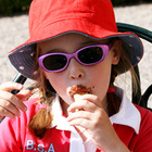 Wer sich mit Sonnenbrille, Sonnenhut oder Sonnencreme vor einer zu hohen UV-Strahlung schützt, meidet Gesundheitsrisiken. Kind mit Sonnenbrille