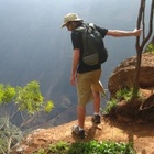 Der Natur nahe zu sein ist ein Aspekt des "sanften" Tourismus - zum Beispiel beim Wandern. Wanderer mit Rucksack an einem Abhang