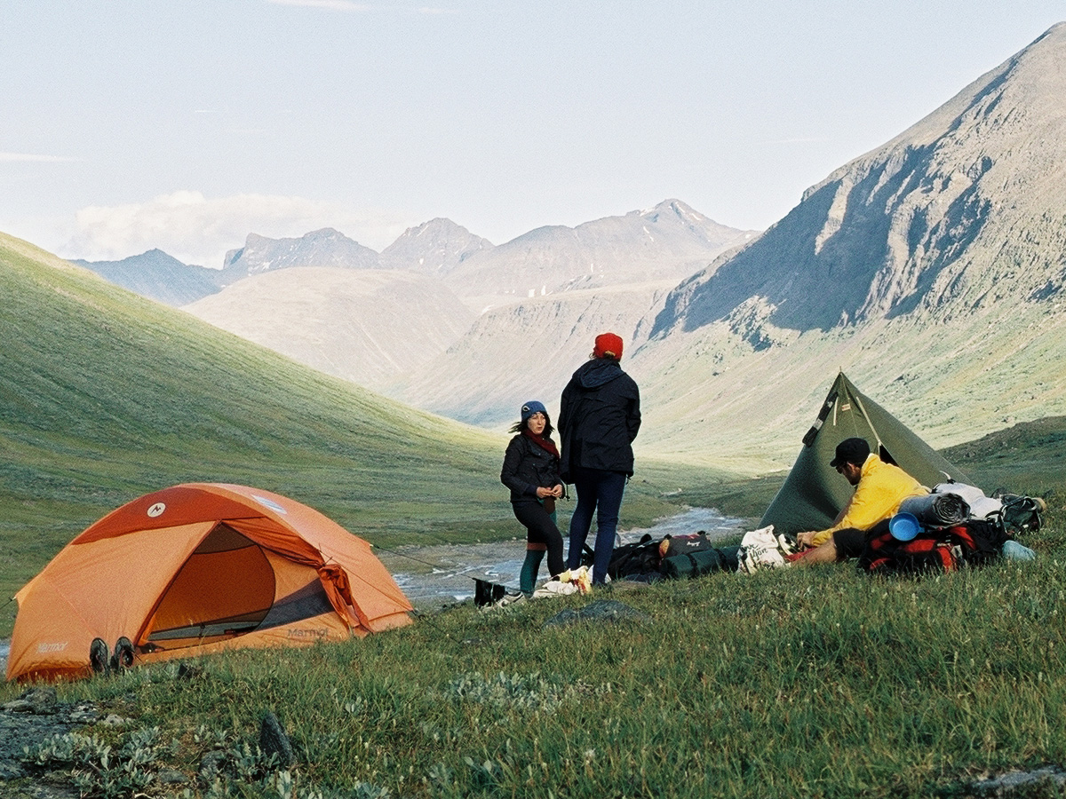 Zelte und Menschen, Berge im Hintergrund