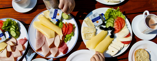 Auf einem Tisch stehen Teller mit Käse und Wurst.
