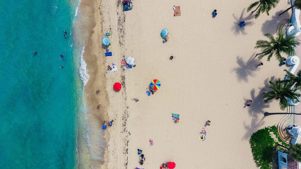 Luftaufnahme von einem Strand mit Sonnenschirmen