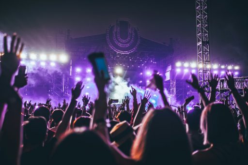 Bühne eines Musikfestivals mit Publikum, das die Hände in die Höhe hält
