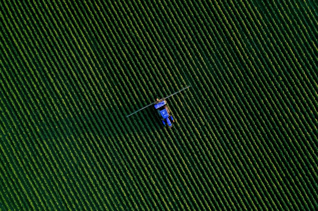 Blauer Traktor auf einem grünen Feld