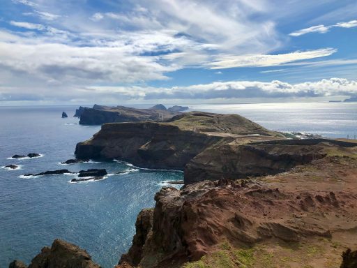 Klippen und Felsen entlang einer Küste unter bewölktem Himmel mit Blick auf das Meer