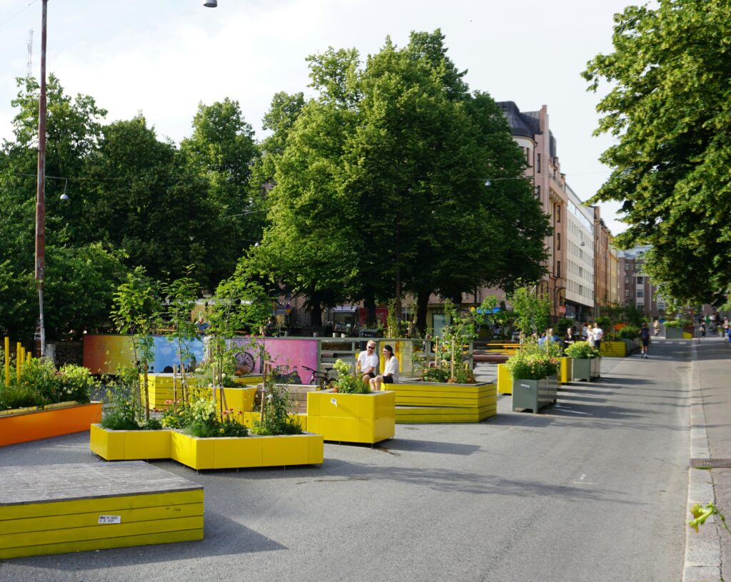Hochbeete mit unterschiedlichen Pflanzen au feiner Straße in einer Stadt.