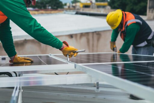 Zwei Handwerker schrauben an einem Solarmodul.
