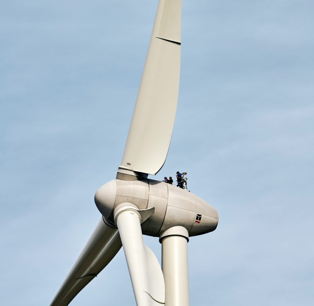 Gondel eines Windkraftwerks mit Menschen darauf.