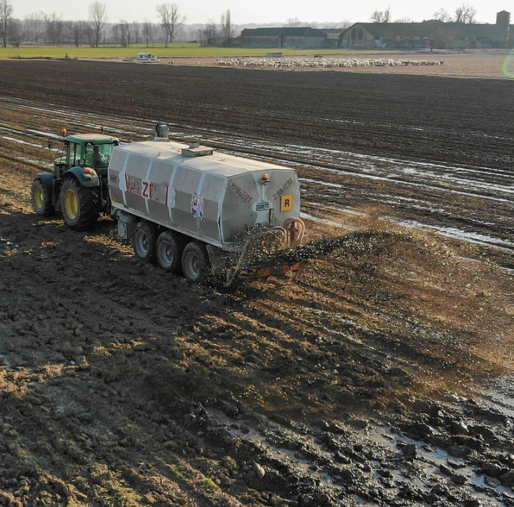 Düngen mit einem Traktor auf einem Feld.