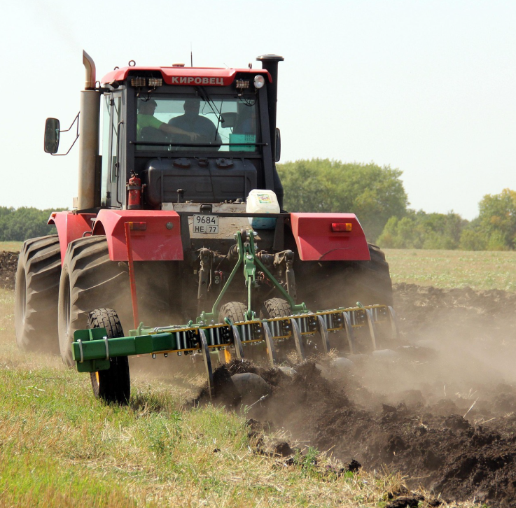 Ein Traktor pflügt den Boden.