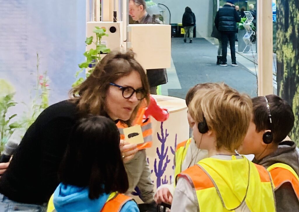 Eine Frau zeigt Kindern ein Bild von einem Maulwurf.