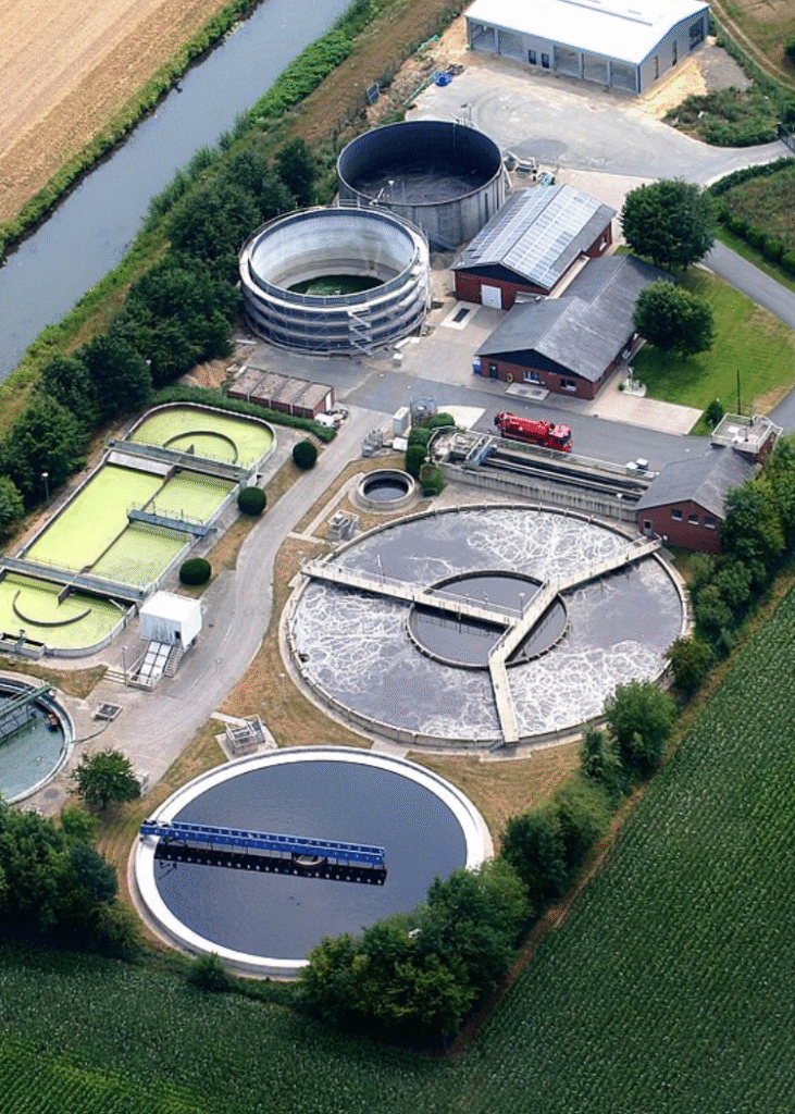 Eine Luftaufnahme von einer Kläranlage mit Wasserbecken und Gebäuden.