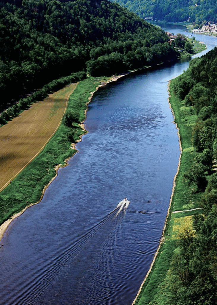 Fluss in einer grünen, bergigen Landschaft.
