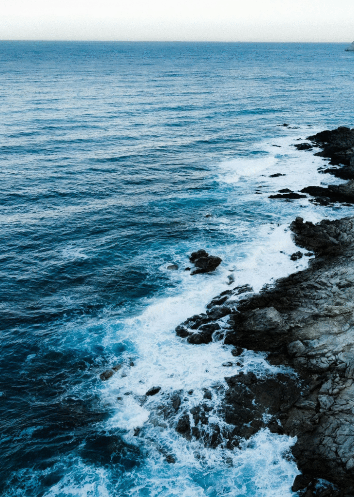 Eine felsige Küste mit schaumigen Meerwasser.