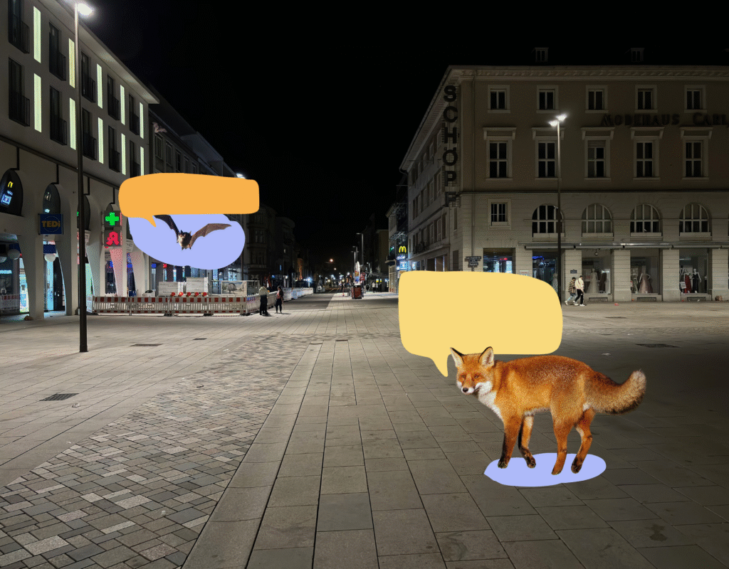 Die Innenstadt von Karlsruhe in der Nacht. Eine breite Straße mit Altbauten. Auf dem Bild sind außerdem eine Fledermaus und ein Fuchs mit großen Sprechblasen.