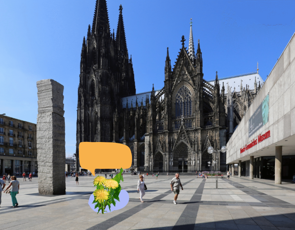 Die Kölner Domplatte mit Passanten. Auf dem Asphalt ist eine gezeichnete Butterblume mit Sprechblase.