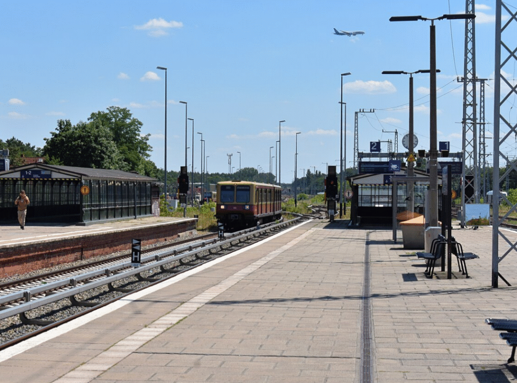 S-Bahn Station in Berlin mit großer Plattform. Eine S-Bahn fährt gerade ein.