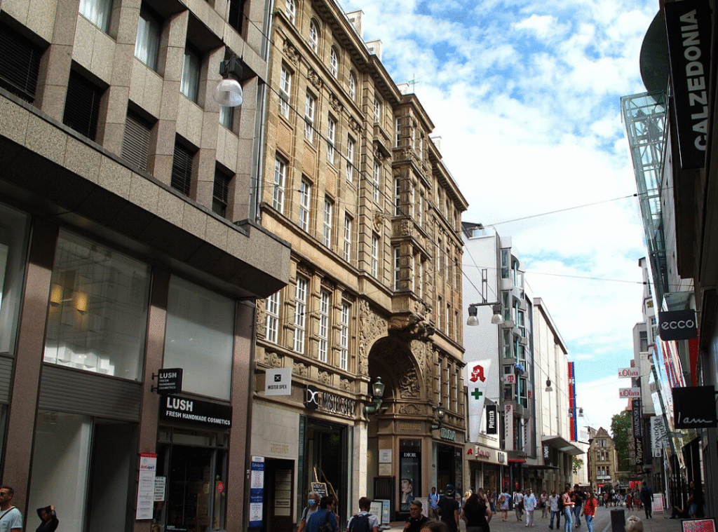 Innenstadt in Dortmund in der Fußgängerzone: Eine enge Straße mit Geschäften und Fußgängern.