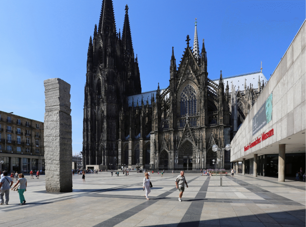 Der Kölner Dom und die Domplatte mit Fußgängern.