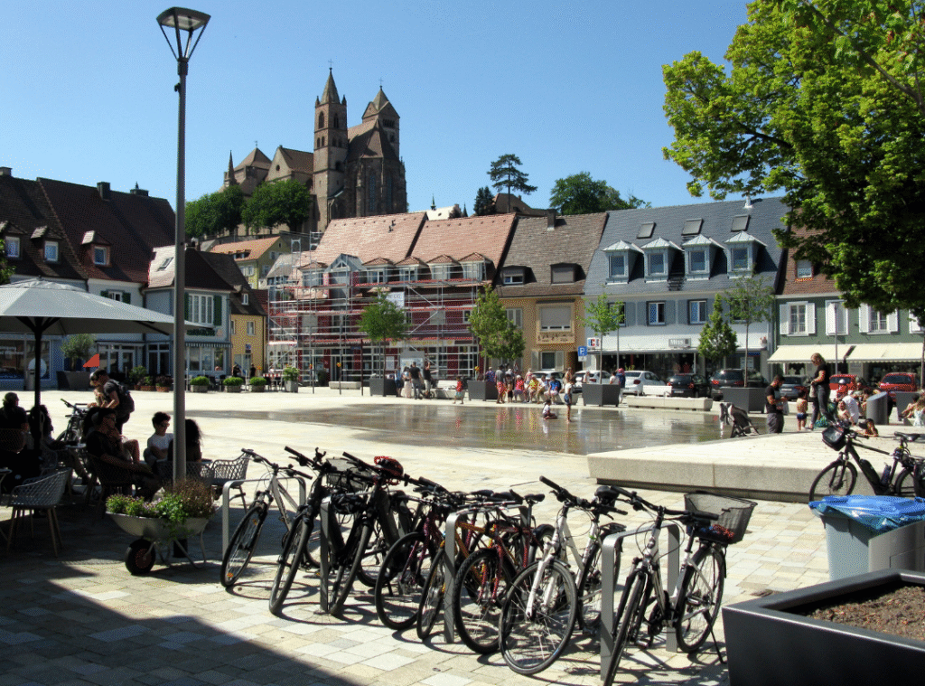 Marktplatz von Breisach mit großer betonierter Fläche begrenzt durch Häuser. 
