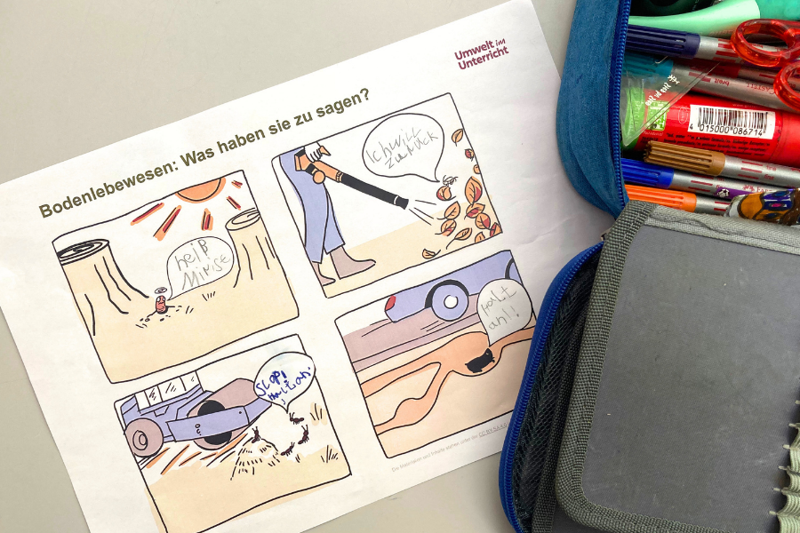 Ein Comic und eine Federtasche liegen auf einem Schultisch.